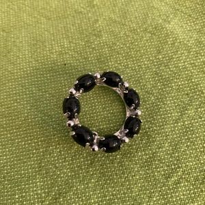 Black stone and silver tone brooch.